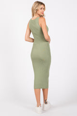 woman wearing a fitted olive green ribbed midi dress and white platform sneakers, viewed from the back
