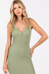 woman wearing a fitted olive green ribbed midi dress with a deep v-neck and button details