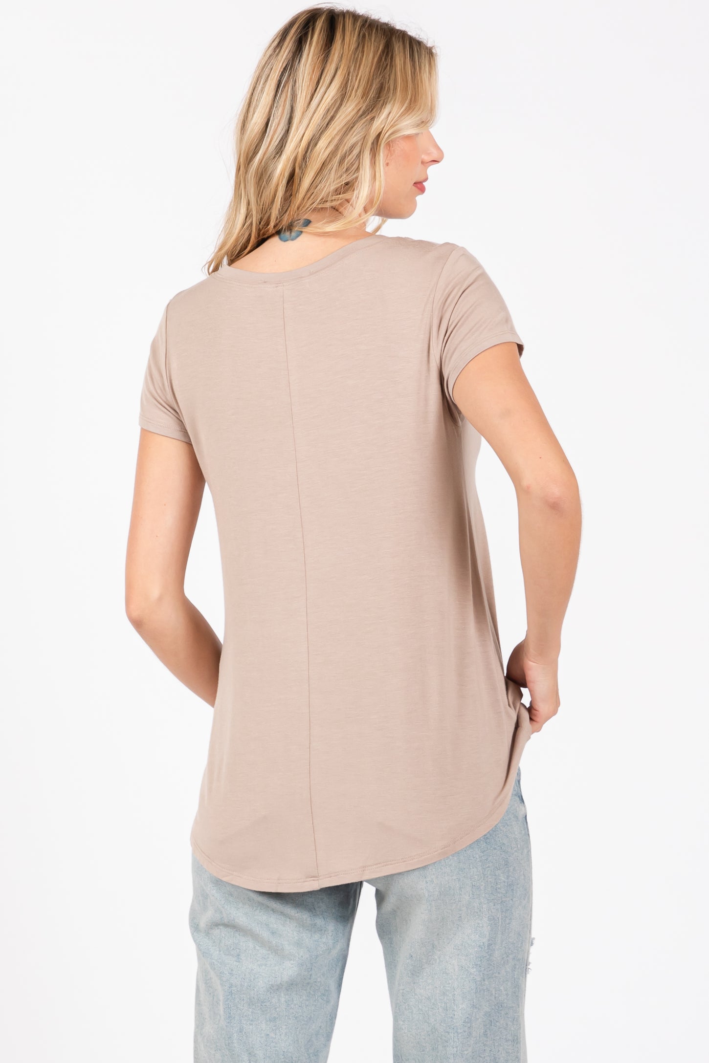 woman wearing a taupe short sleeve top with a rounded hem and back seam detail