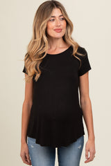 woman wearing a black maternity top with short sleeves and a relaxed fit, showing her baby bump