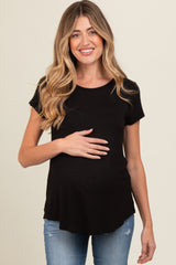 woman wearing a black short sleeve maternity top and holding her baby bump
