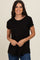 woman wearing a black short sleeve t-shirt and blue jeans, smiling at the camera