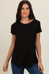 woman wearing a black short sleeve top with a relaxed fit and round neckline, paired with blue jeans