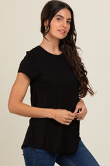 woman wearing a black short sleeve t-shirt with a relaxed fit, standing confidently and smiling