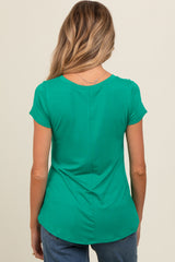 woman wearing a green short sleeve maternity top with a curved hem and back seam details