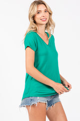 woman wearing a green v-neck t-shirt with short sleeves and distressed denim shorts