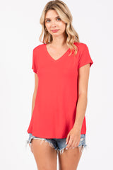 woman wearing a red v-neck t-shirt with short sleeves and distressed denim shorts