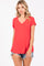 woman wearing a red v-neck t-shirt with short sleeves and distressed denim shorts