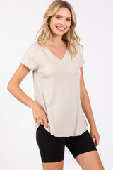 woman wearing a beige v-neck short sleeve t-shirt paired with black bike shorts