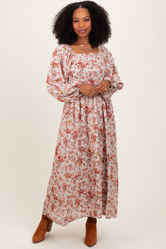 woman wearing a long sleeve floral maxi dress with a square neckline and gathered waist, paired with ankle boots