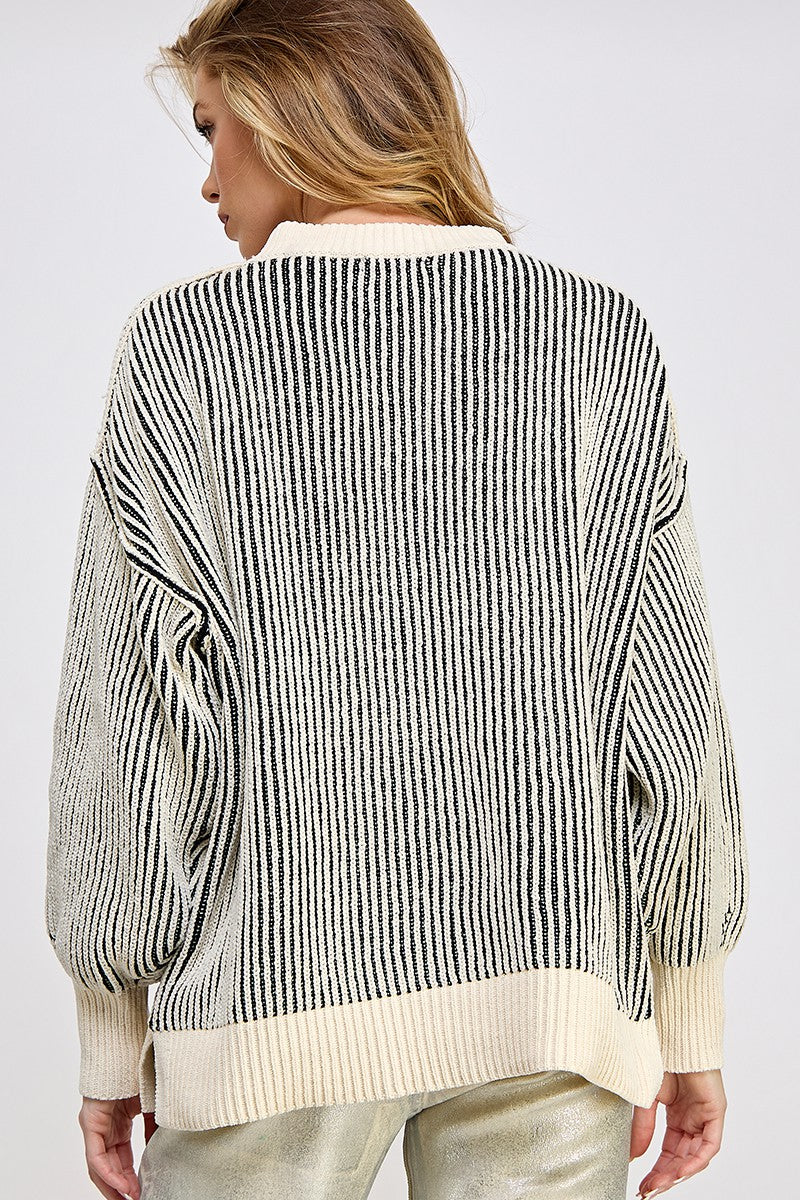 woman wearing a cream and black striped oversized sweater, showing the back view and puffed sleeves