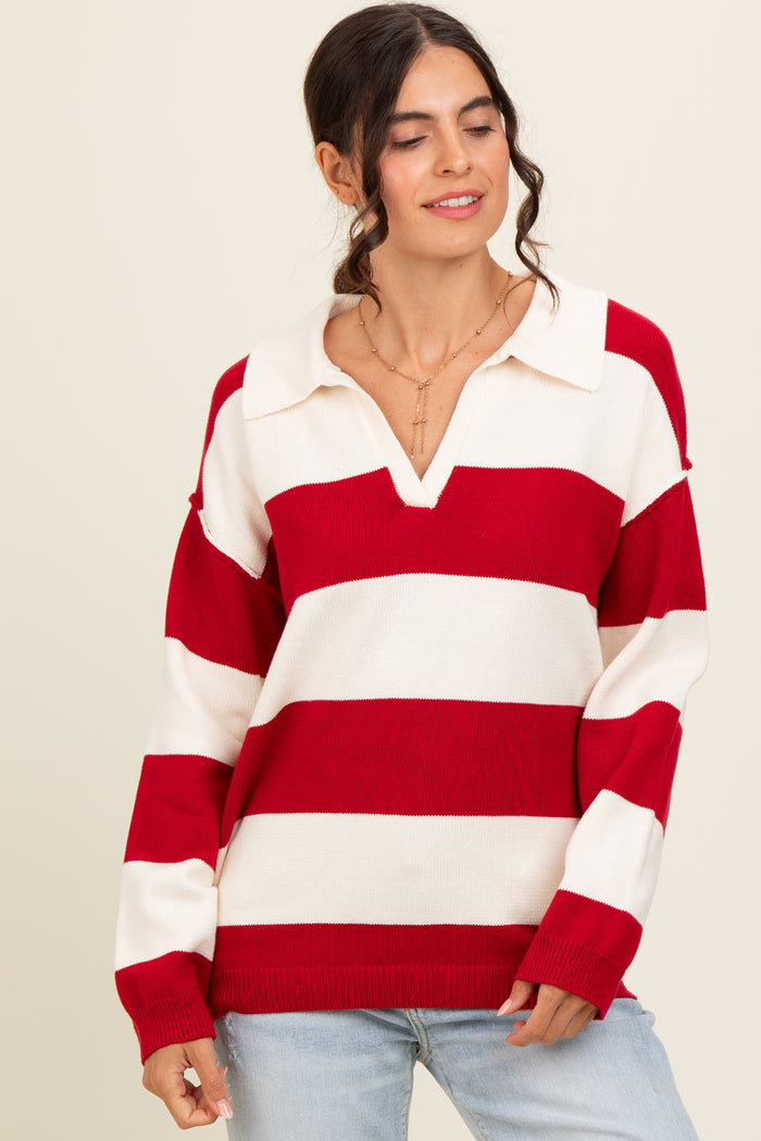woman wearing a red and white striped oversized sweater with a collar and v-neckline, paired with light blue jeans