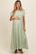 woman wearing a light green maxi maternity dress and holding her baby bump