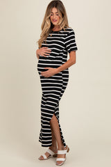 woman wearing a black and white striped maternity maxi dress with side slits and holding her baby bump