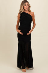 woman wearing a black one-shoulder maternity gown with ruching, holding her baby bump