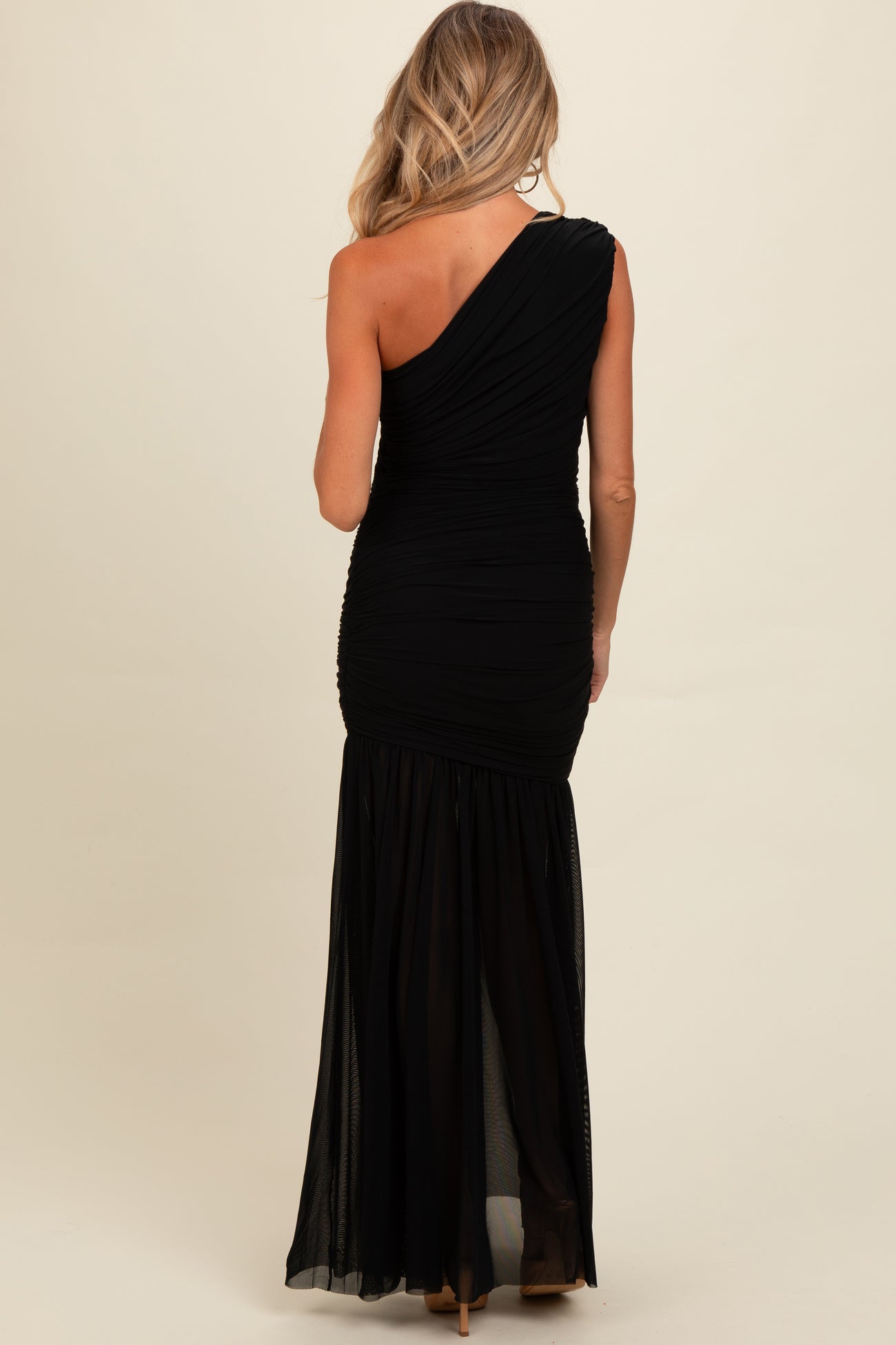 woman wearing a black one-shoulder ruched maternity gown with a flowy skirt and fitted bodice
