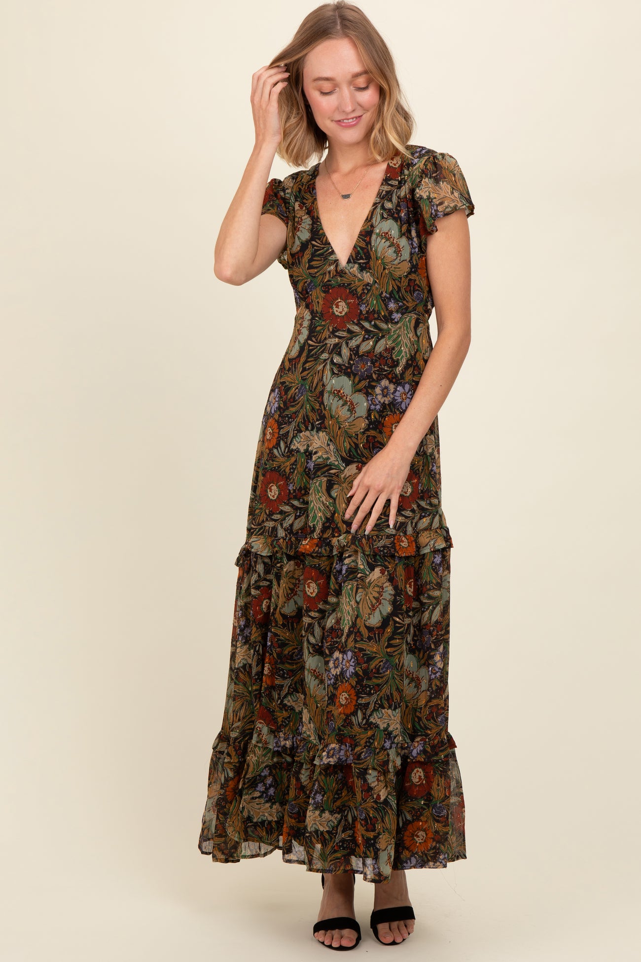 woman wearing a floral maxi dress with ruffle details and a deep V-neckline