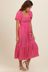 woman wearing a pink floral midi dress with puff sleeves and a smocked bodice