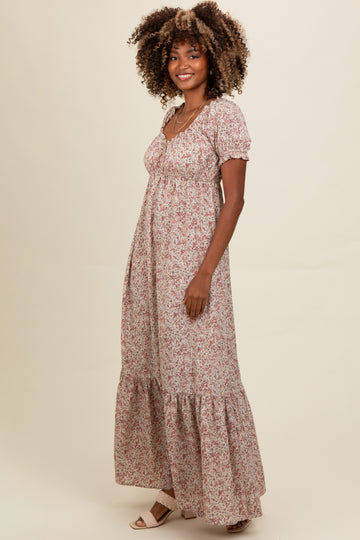 woman wearing a floral maxi dress with puff sleeves and a tiered hem, standing against a neutral background