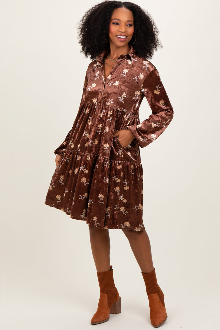 woman wearing a brown velvet floral long sleeve dress with pockets and a tiered skirt, styled with ankle boots