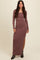 woman wearing a mauve long sleeve ribbed maxi dress with a side slit and black ankle boots