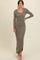 woman wearing a long olive green ribbed maxi dress with long sleeves and a side slit