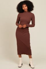 woman wearing a brown long sleeve ribbed midi dress with a scalloped hem and white ankle boots