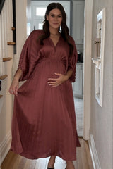 woman wearing a mauve maternity wear pleated maxi dress and holding her baby bump