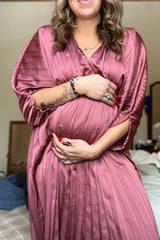 woman wearing a mauve pleated maternity robe and holding her baby bump