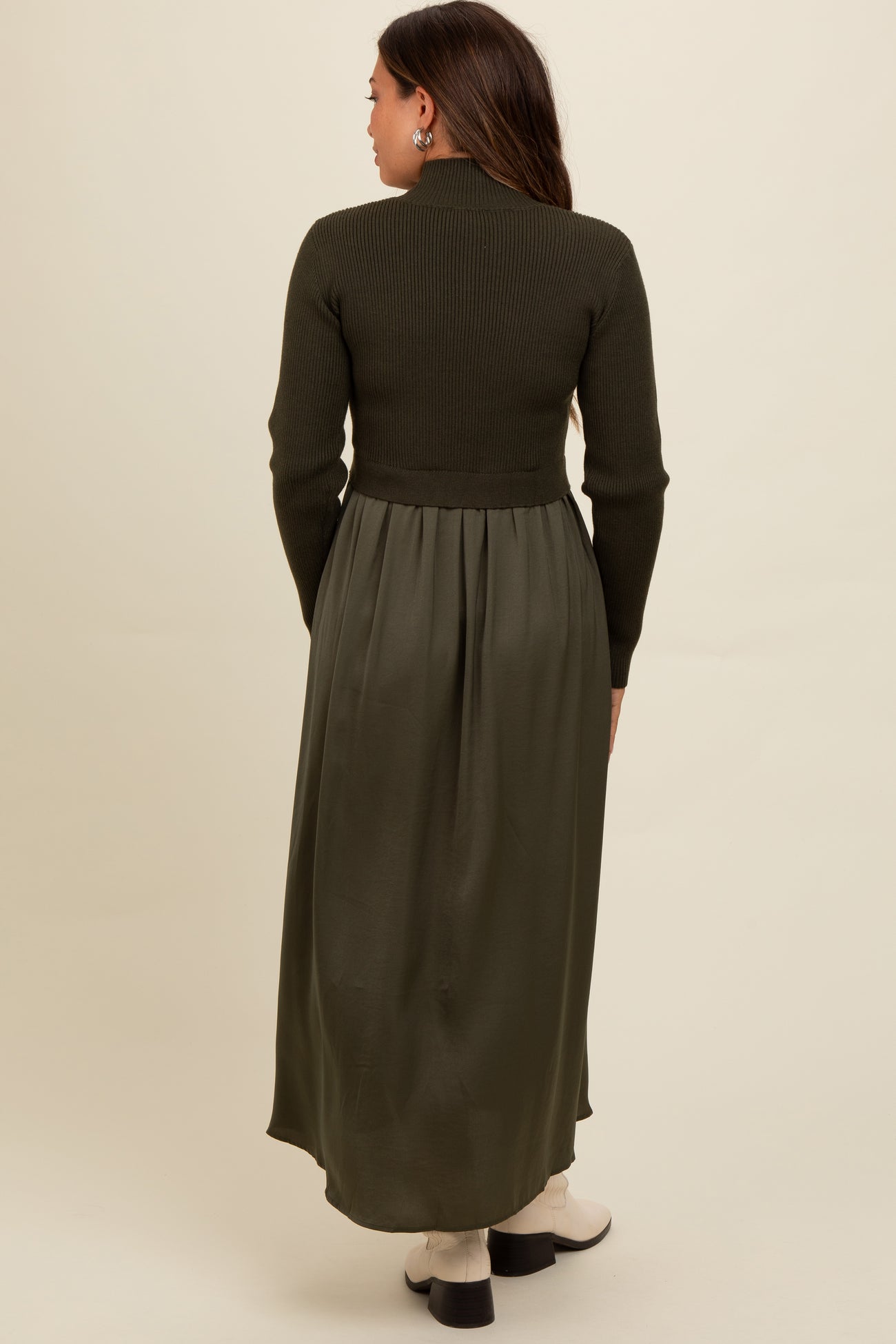 woman wearing a dark green maternity dress with a ribbed top and flowing skirt, viewed from the back