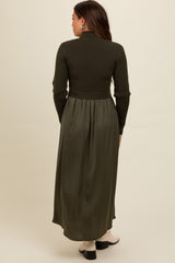 woman wearing a dark green maternity dress with a ribbed top and flowing skirt, viewed from the back