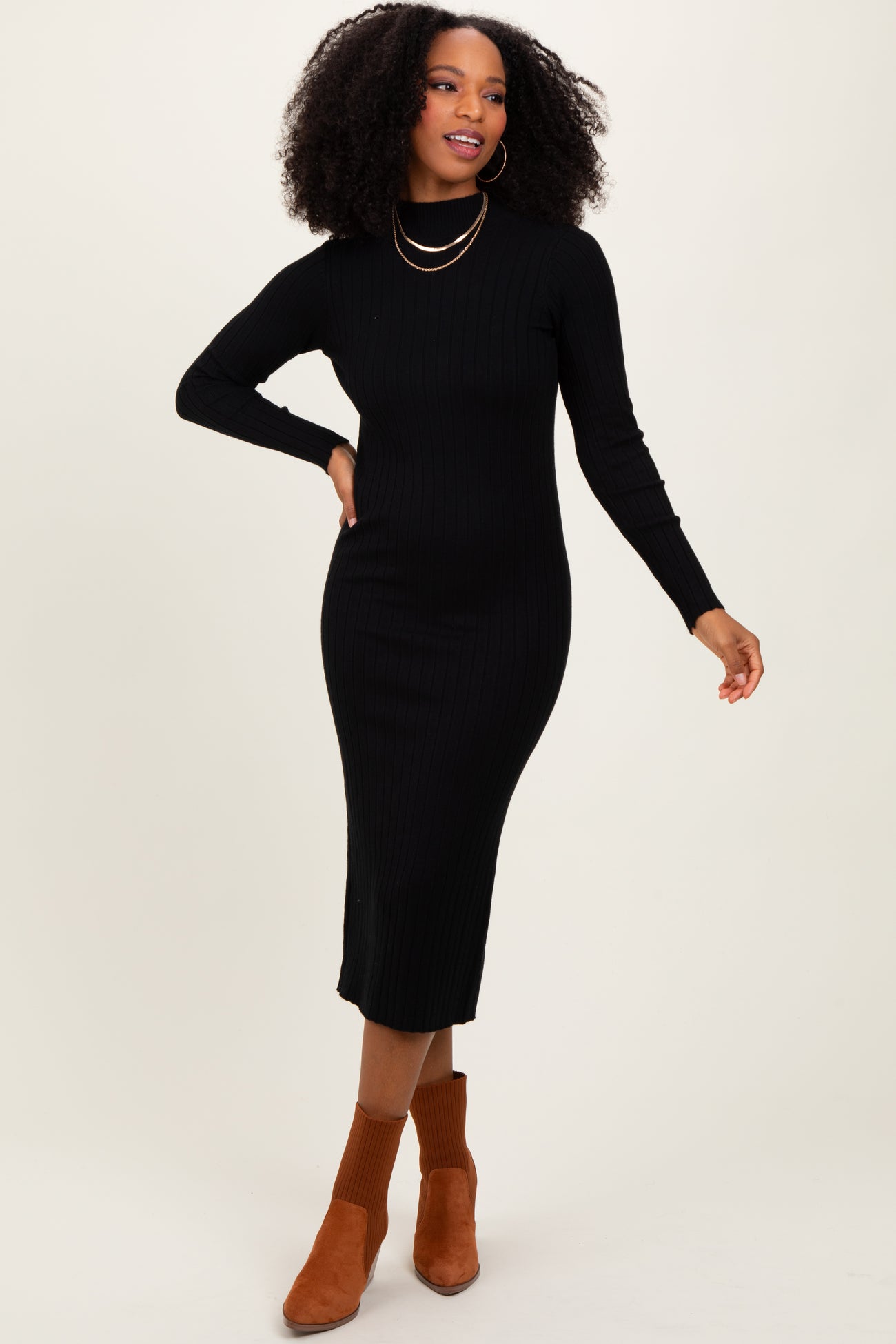 woman wearing a black ribbed turtleneck midi dress and brown ankle boots