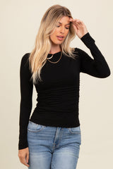 woman wearing a black long sleeve fitted top with gathered side detail and blue jeans
