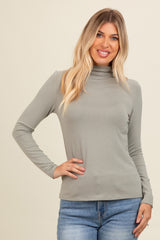 woman wearing a light grey long sleeve mock neck top with a fitted style and casual look