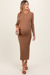 woman wearing a brown ribbed maternity dress with long sleeves and a visible baby bump, carrying a crossbody bag