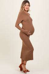 woman wearing a brown ribbed maternity dress and holding her baby bump