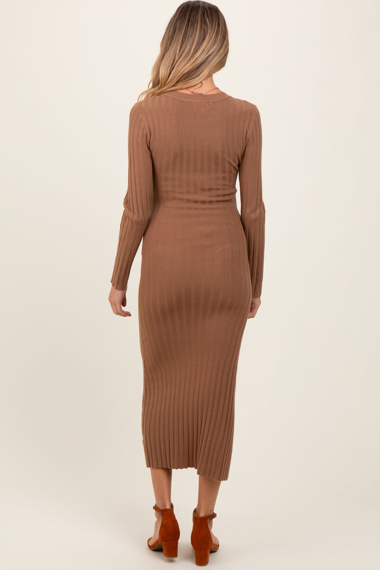 woman wearing a brown ribbed long sleeve maternity dress that reaches mid-calf length