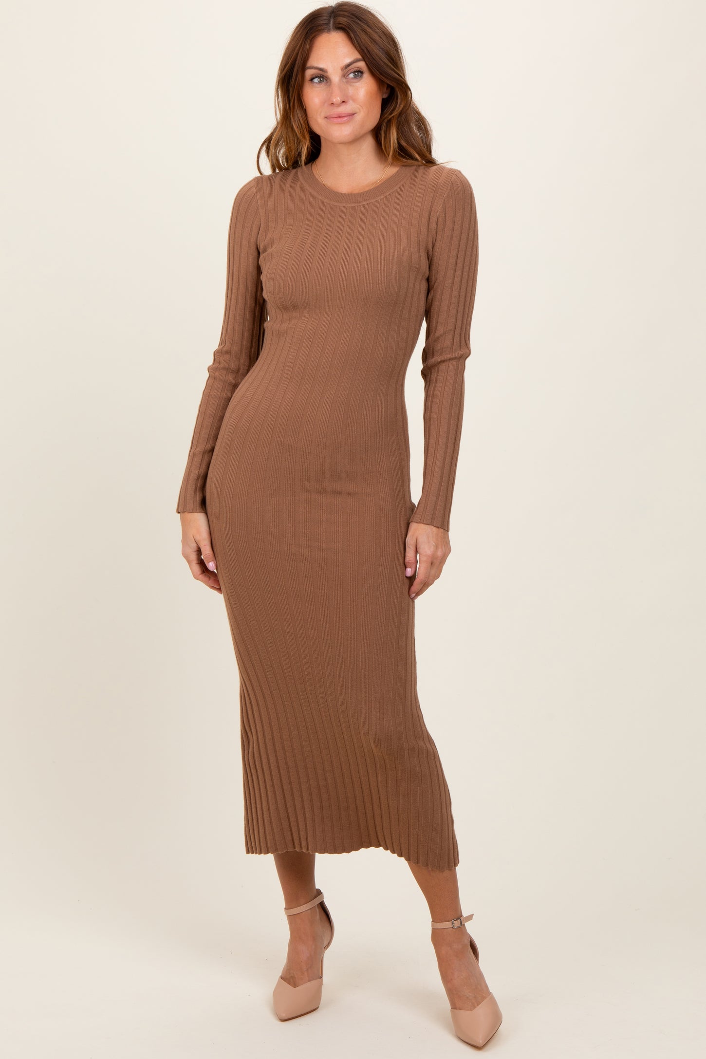 woman wearing a ribbed long sleeve midi dress in brown with a fitted silhouette and side slit