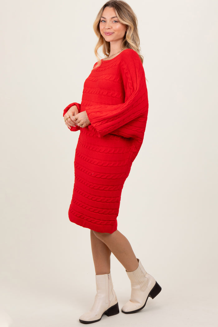 woman wearing a vibrant red cable knit sweater dress with long sleeves and heeled ankle boots