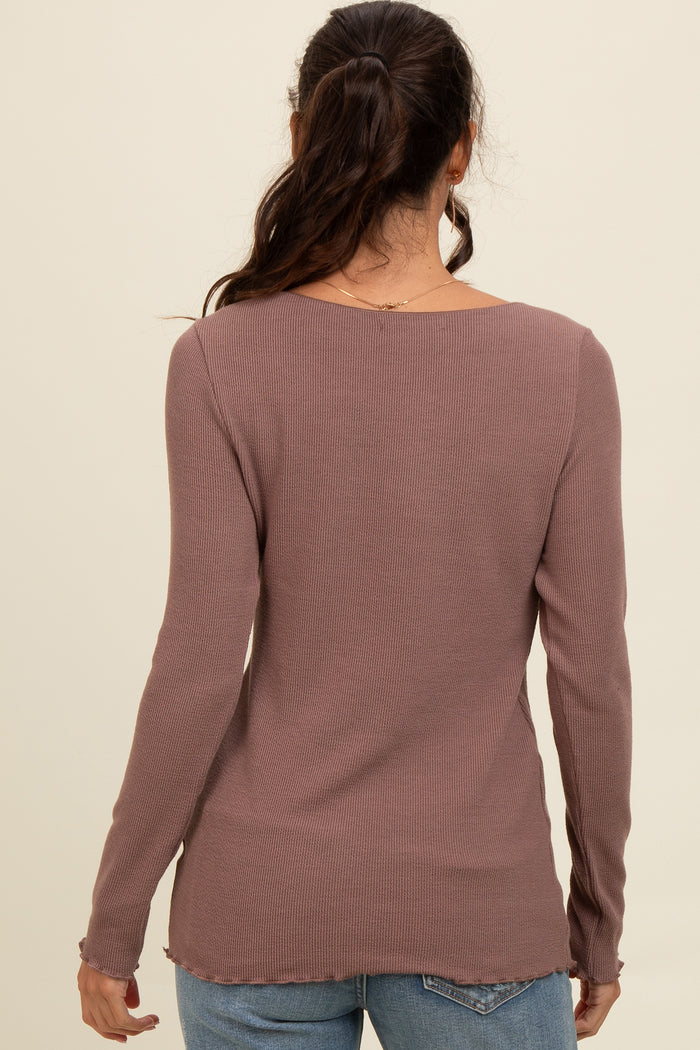 woman wearing a dusty mauve ribbed long sleeve top with a rounded neckline and frayed hem, seen from the back