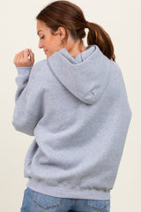 woman wearing a light gray oversized hoodie from the back with a hood and long sleeves