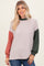 woman wearing a ribbed color block long sleeve sweater in light beige, green, and rust with a relaxed fit