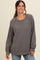 woman wearing a gray long sleeve waffle knit sweatshirt and smiling