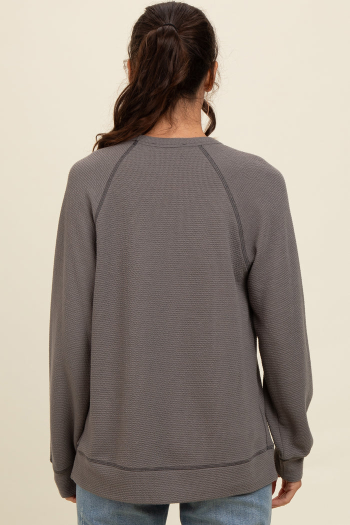 woman wearing a gray long sleeve sweatshirt with a relaxed fit and raglan sleeves, viewed from the back