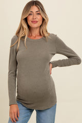 woman wearing a ribbed olive green maternity top, showcasing a visible baby bump with long sleeves and a round neckline