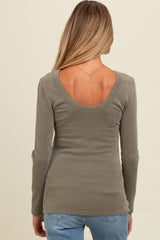 woman wearing a green ribbed long sleeve maternity top with a scoop back detail