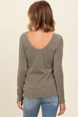 woman wearing a light olive ribbed long sleeve top with a scoop back and styled with blue jeans