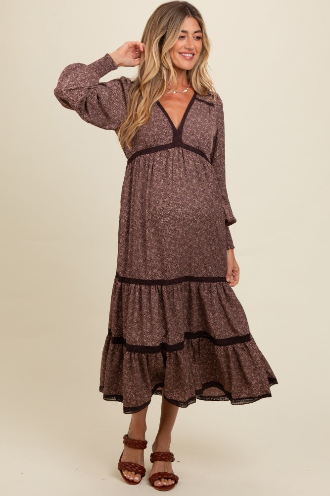 woman wearing a burgundy floral maternity maxi dress with tiered hem and a visible baby bump
