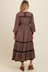 woman wearing a brown floral maternity maxi dress with long sleeves and tiered ruffles, showing a relaxed fit