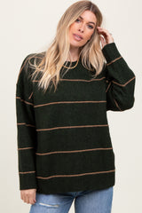 woman wearing a dark green striped sweater with beige lines and long sleeves paired with light blue jeans